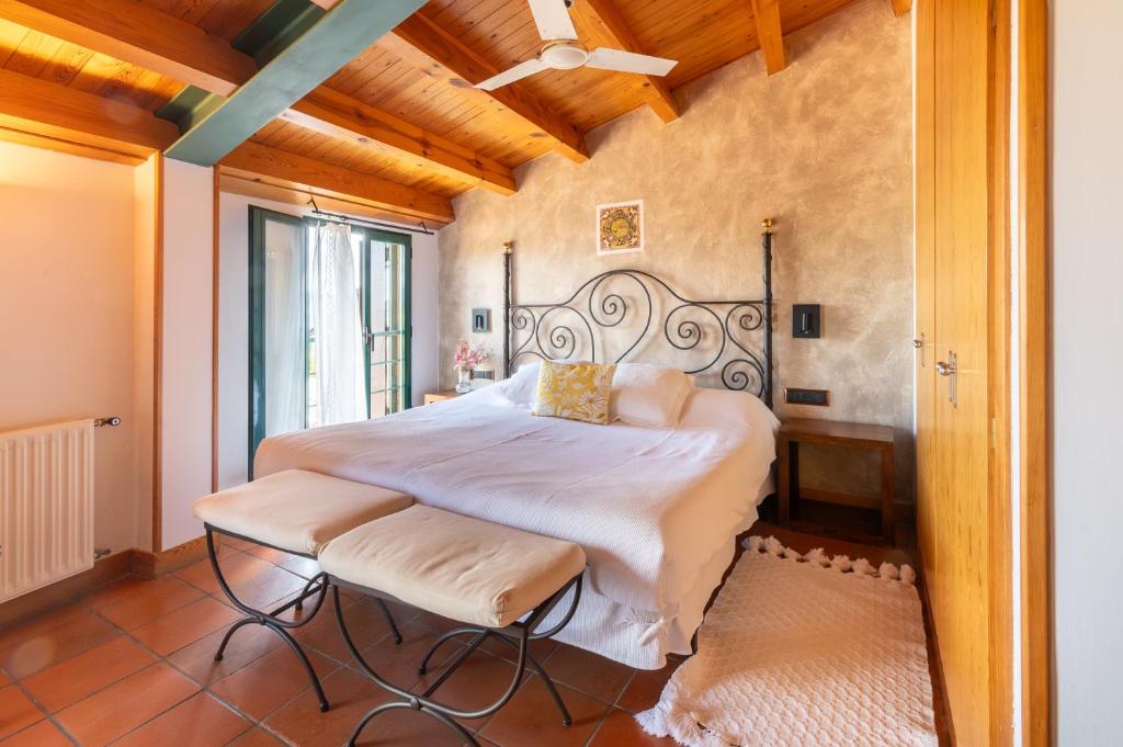 ein Schlafzimmer mit einem großen Bett in einem Zimmer in der Unterkunft Hospedería el arco in Villavieja del Lozoya