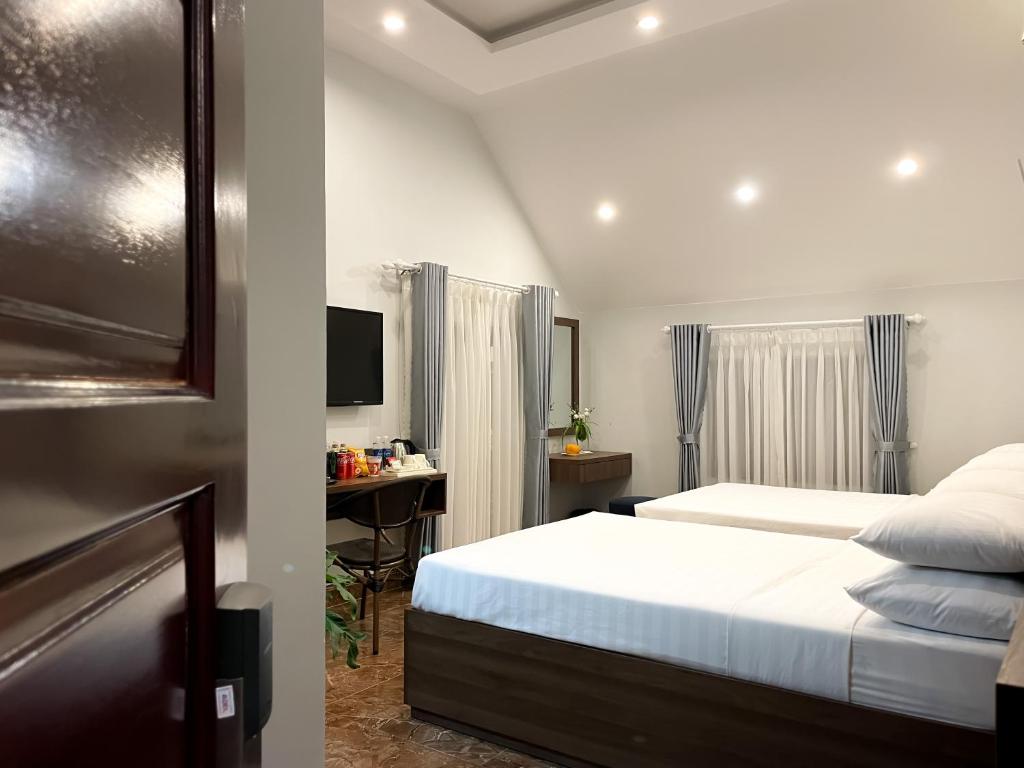 ダラットにあるSunshine Villa Dalatのベッドとパソコン付きの机がある寝室