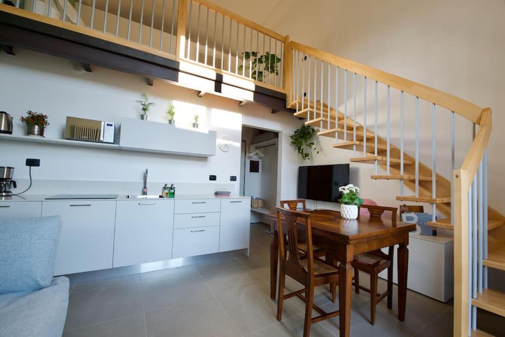 uma cozinha e sala de jantar com uma mesa e uma escada em Trevisan Loft: Slow Food, Langhe, and Comfort em Bra