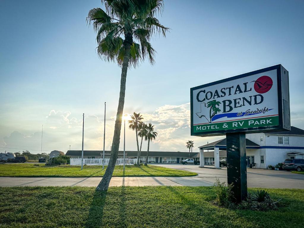 een palmboom en een bord voor een gebouw bij Coastal Bend at Seadrift, Motel & RV Park in Seadrift