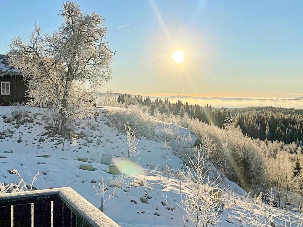 a snow covered field with the sun in the sky at Holiday home Fall in Raufoss