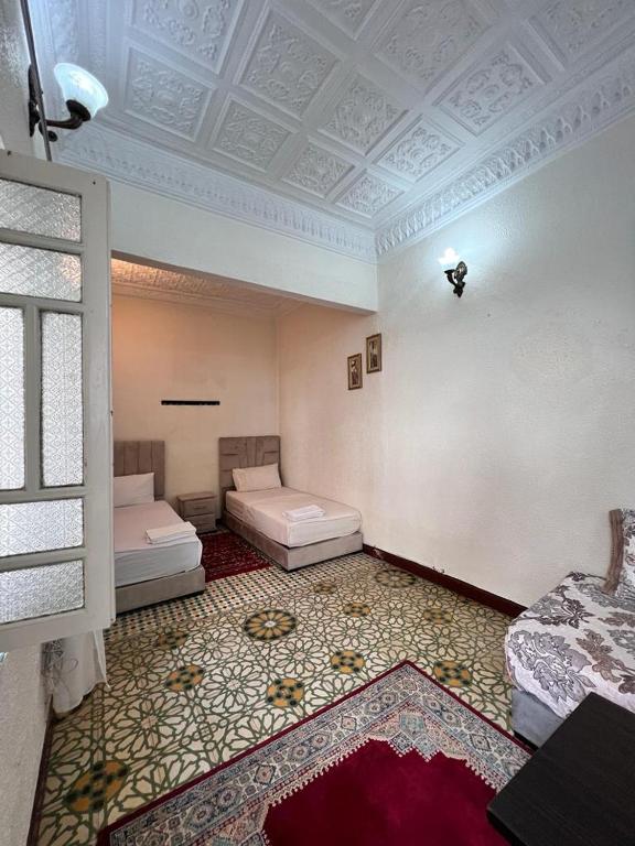 a room with two beds and a ceiling at Riad Del Rey in Rabat