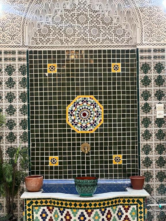 a tile wall with an umbrella on top of it at Riad Del Rey in Rabat