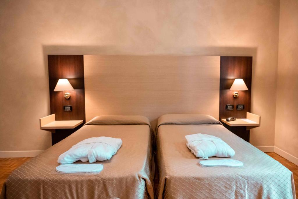 a bedroom with two beds with pillows on them at Hotel Terme Pellegrini in Montecatini Terme