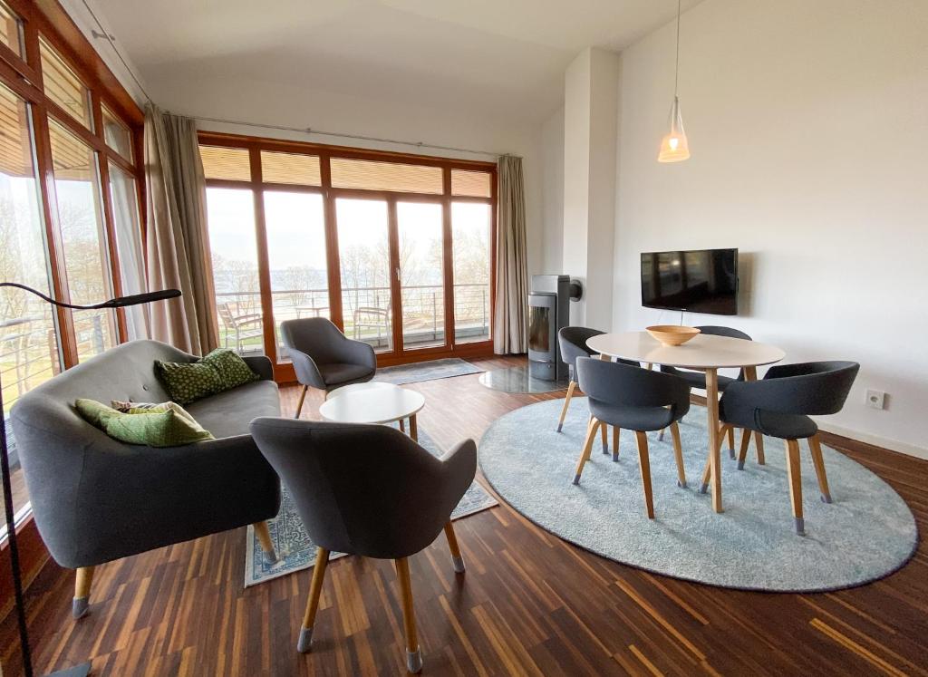 a living room with a couch and a table and chairs at Wiesengeflüster Apartment 433 in Klink mit Müritzblick, Balkon und Strandnähe in Klink