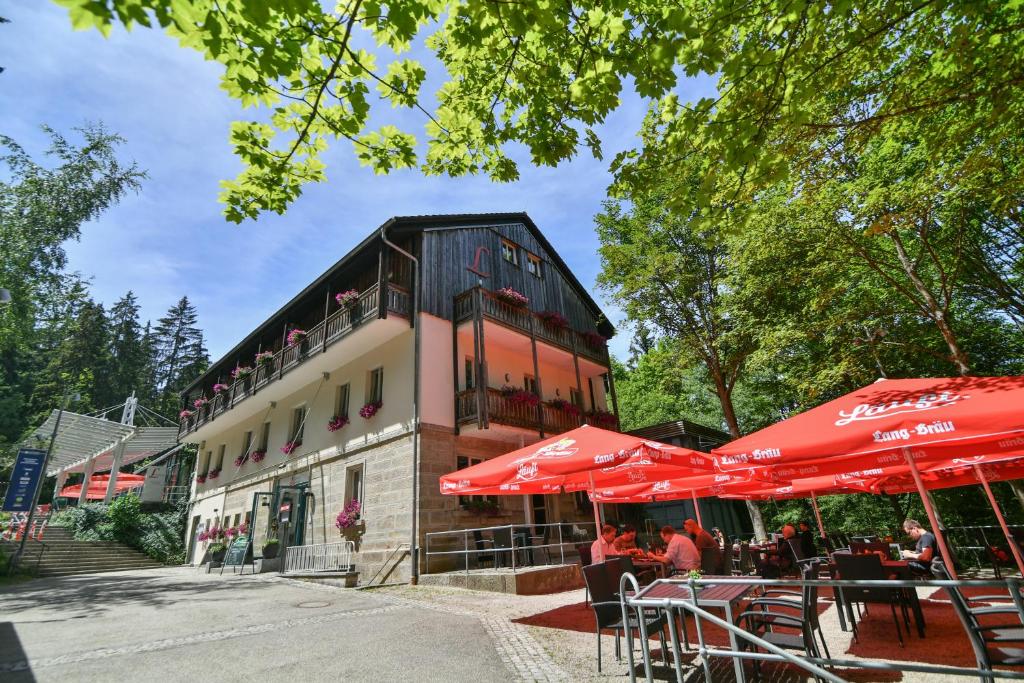 a building with tables and umbrellas in front of it at Luisenburg Resort in Wunsiedel