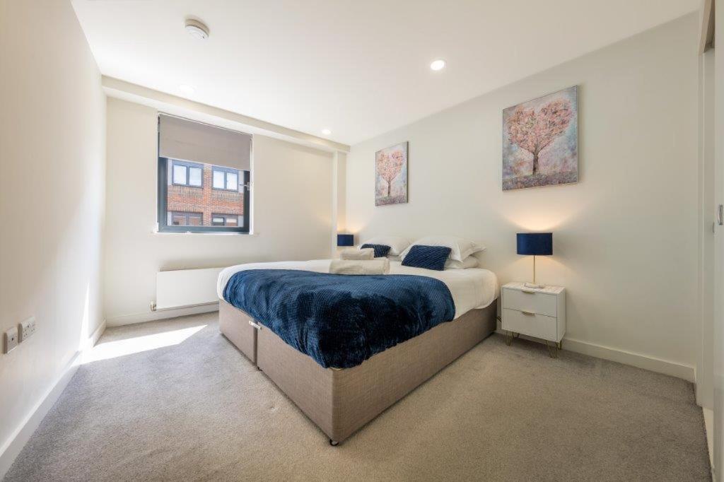 a white bedroom with a large bed and a window at Modern 1 Bedroom Apartment in the center of Bedford in Bedford
