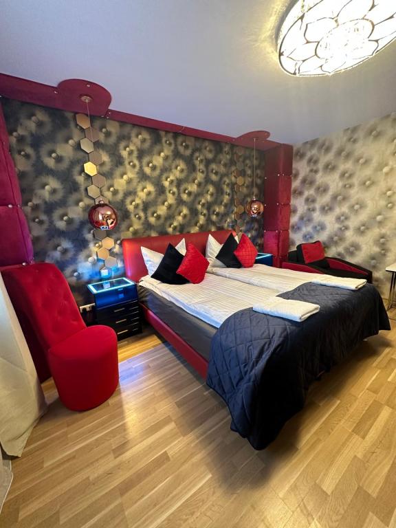 a bedroom with a large bed and a red chair at Diamanthaus deluxe 7 Koblenz in Koblenz