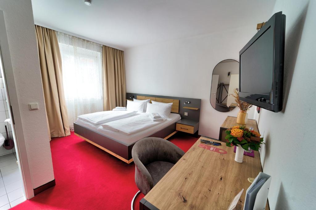 a hotel room with a bed and a tv at Hotel Tanne in Saalfeld