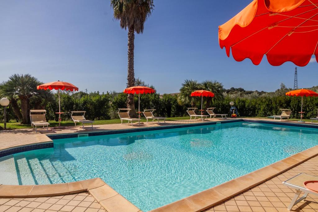 a large swimming pool with chairs and umbrellas at Farfalla in Montiano