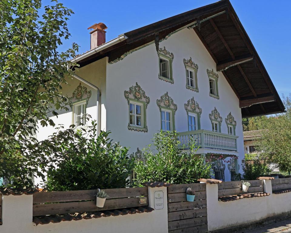 una casa blanca con detalles ornamentales en la fachada en Ferienwohnung Gartenglück en Traunstein