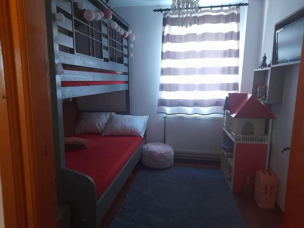een kleine kamer met een stapelbed en een raam bij Victoria Apartment Luxury in Târgu Jiu