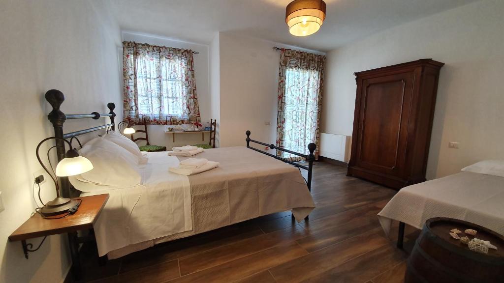 Un dormitorio con una cama y una mesa y dos ventanas. en DOMU NOSTA di Giulio & Ignazia Room3, en Santa Luria