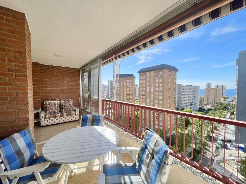 a balcony with a table and chairs and a view of the city at Principado Wifi, Airco, Beach and Garden in Benidorm