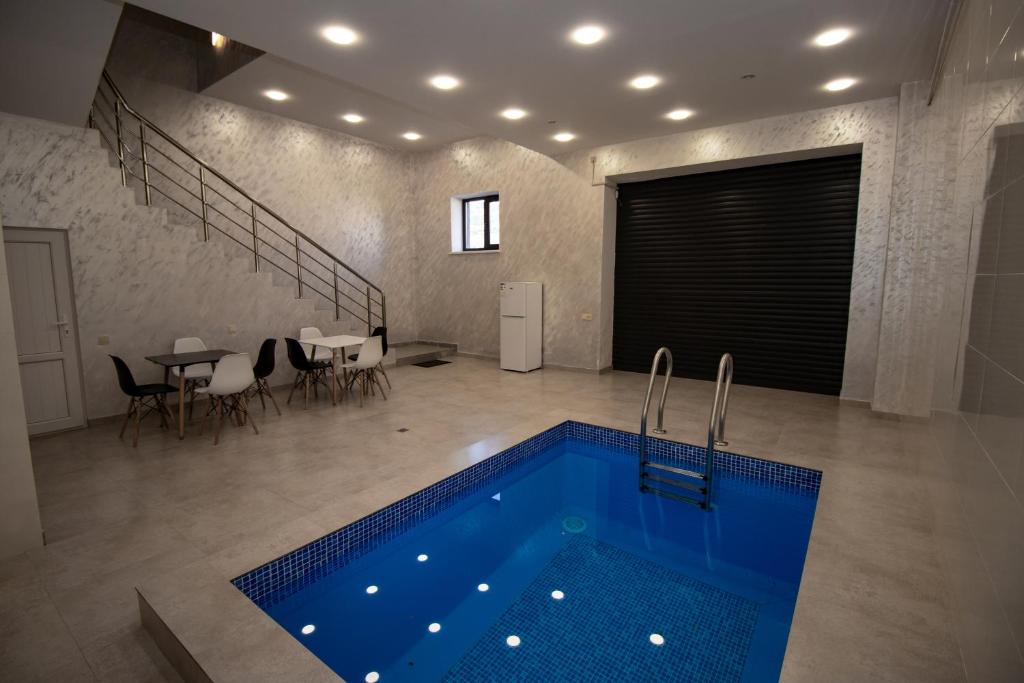 a swimming pool in a room with a table and chairs at Happy home in Tsaghkadzor