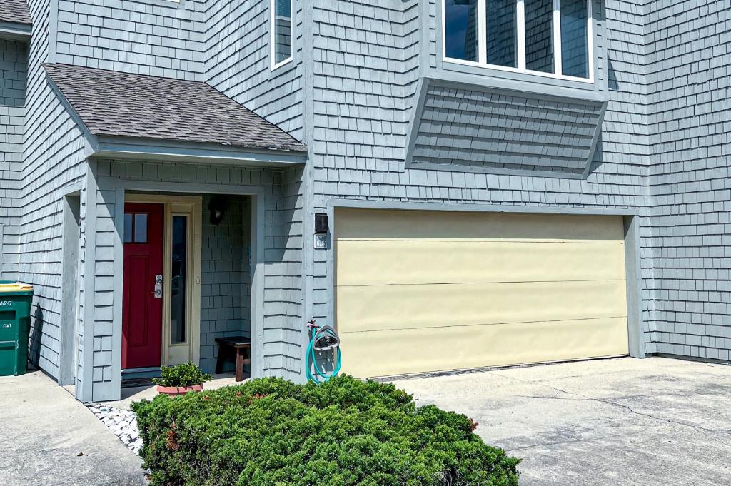 a house with a garage with a red door at Villa Del Mar in Corolla