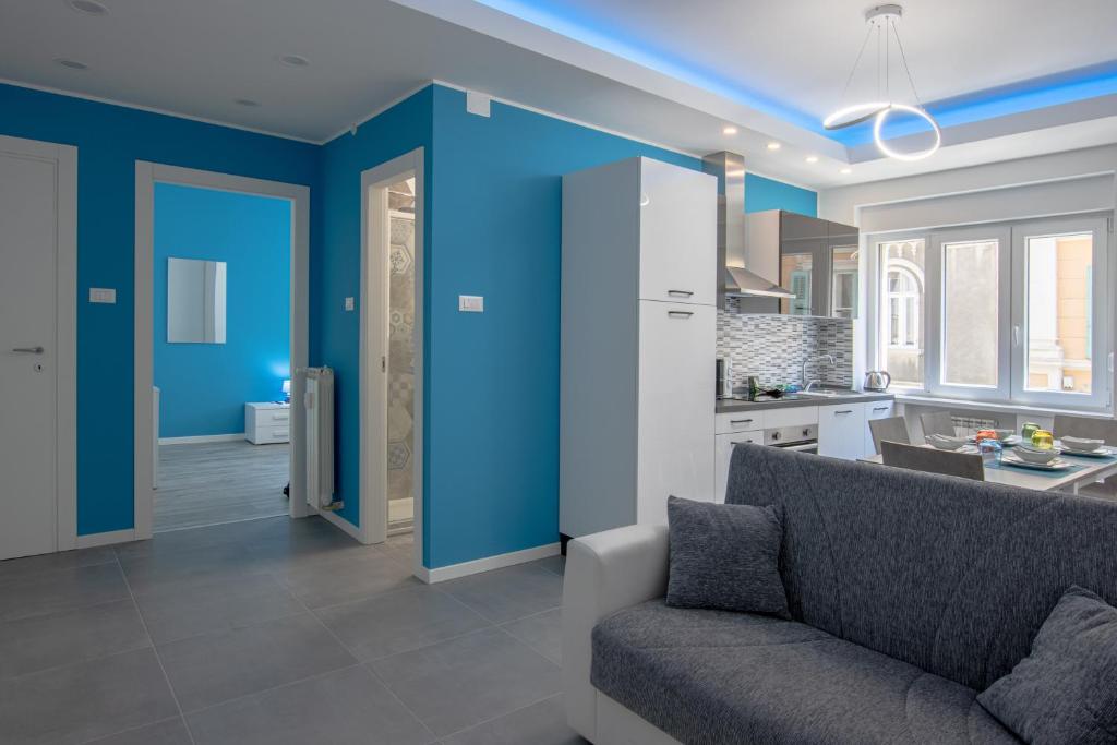 un soggiorno con pareti blu e divano di [Fibra SuperFast] Politeama Rossetti Modern Suite a Trieste