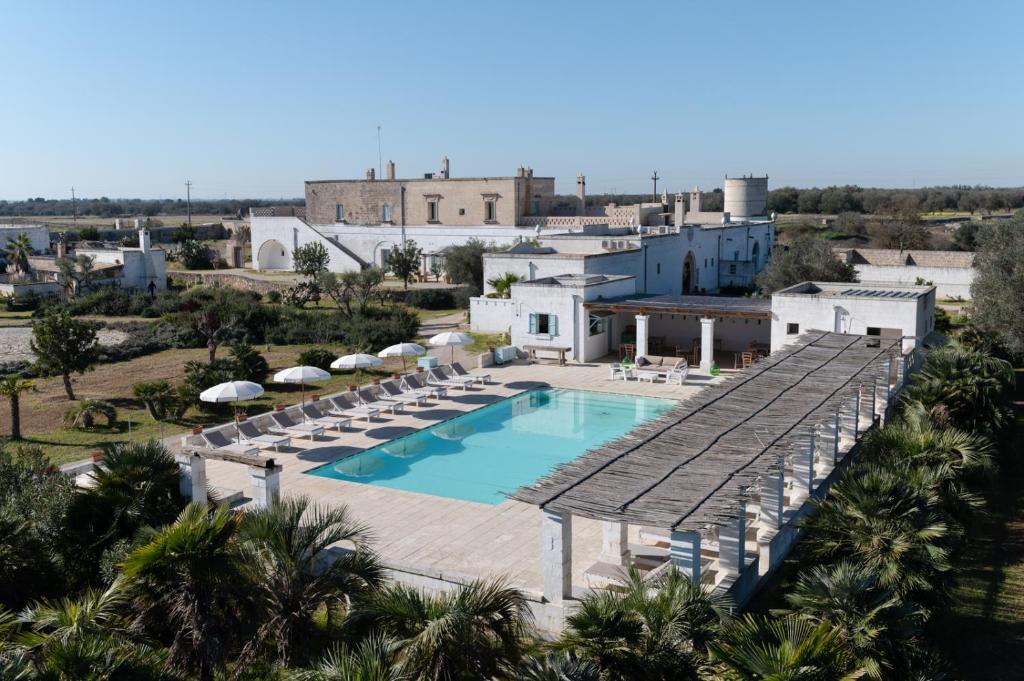 an aerial view of a pool with chairs and umbrellas at Masseria Palombara Resort & SPA - Adults only in Manduria