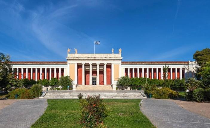 a large building with red and white columns at Charming Green Studio across the National Museum in Athens