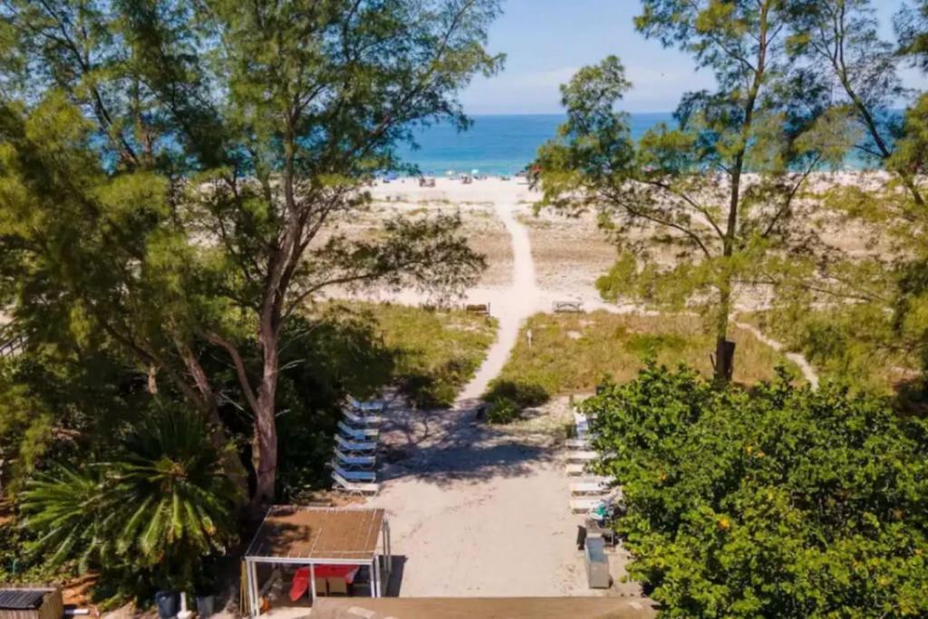 een uitzicht op een strand met bomen en de oceaan bij Exclusive Access to a Gorgeous Private Beach 1BR in St Pete Beach