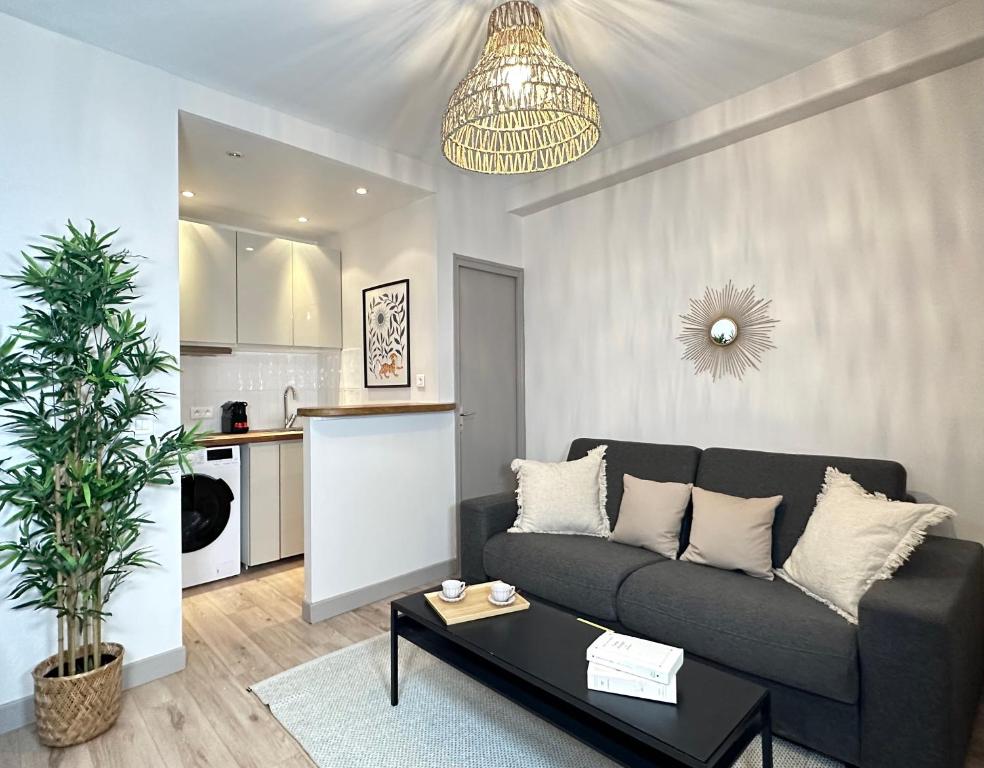 ein Wohnzimmer mit einem Sofa und einem Tisch in der Unterkunft 2067 - Elegant home in Trocadéro Olympic Games 2024 in Paris