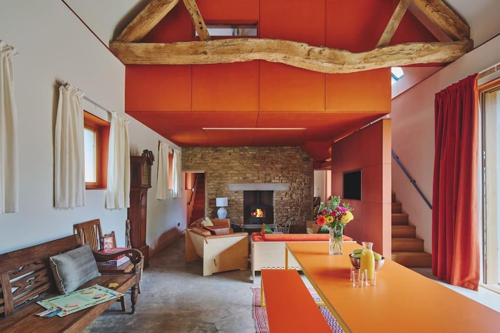 a living room with red walls and a table at A Digital Detox in the Cotswolds - Langley Barn in Winchcombe