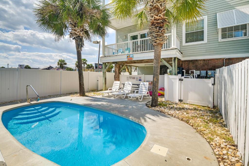 a swimming pool in front of a house with palm trees at Surfside Beach House with Pool, Walk to Beach and Pier in Myrtle Beach