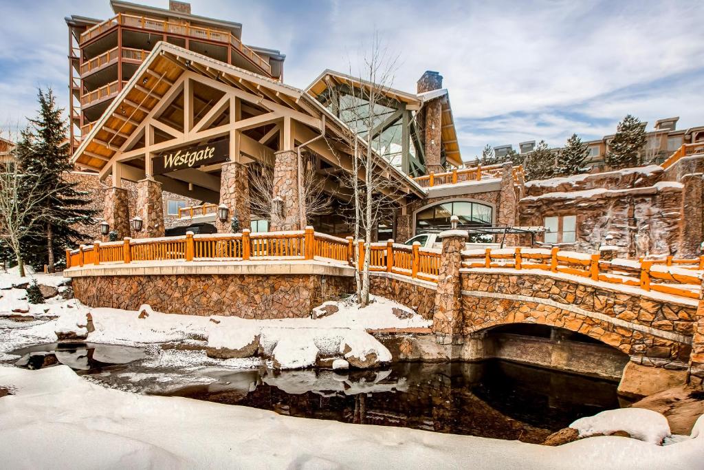 a building with a bridge over a pond in the snow at Westgate Mountain Retreat in Park City