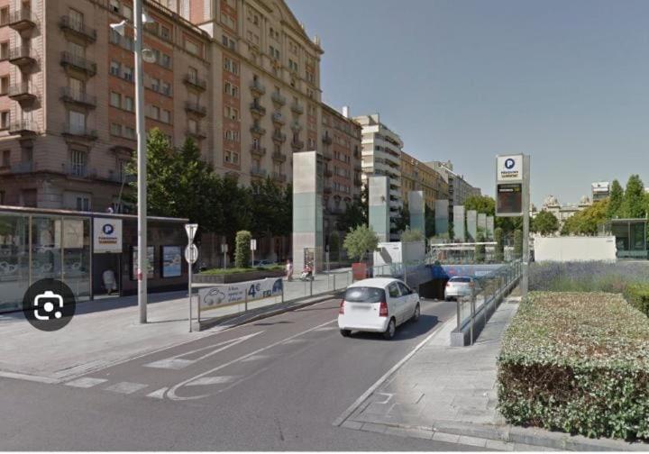 a white car is driving down a city street at Pension Suiza in Reus