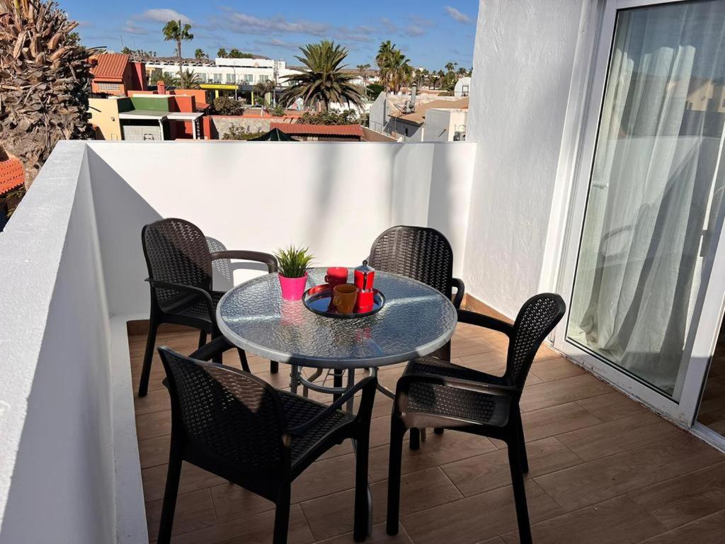 un tavolo e sedie su un balcone con tavolo di Apartamento Marae a Corralejo