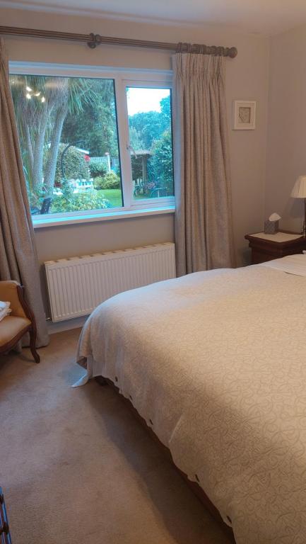 um quarto com uma cama grande e uma janela em Knockrobin Cottage em Wicklow