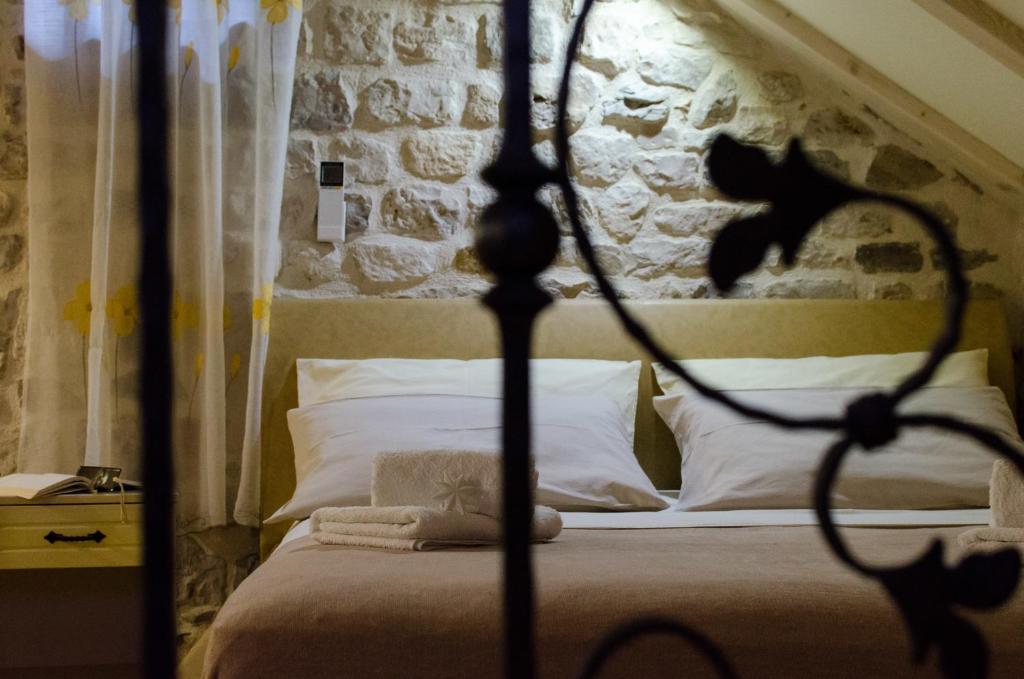 a bedroom with a bed with a stone wall at Apartments Kaja in Trogir