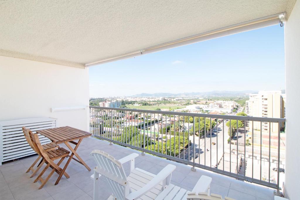 balcón con mesa, sillas y vistas en Global Properties, Moderno apartamento con piscina en la playa de Canet, en Canet de Berenguer
