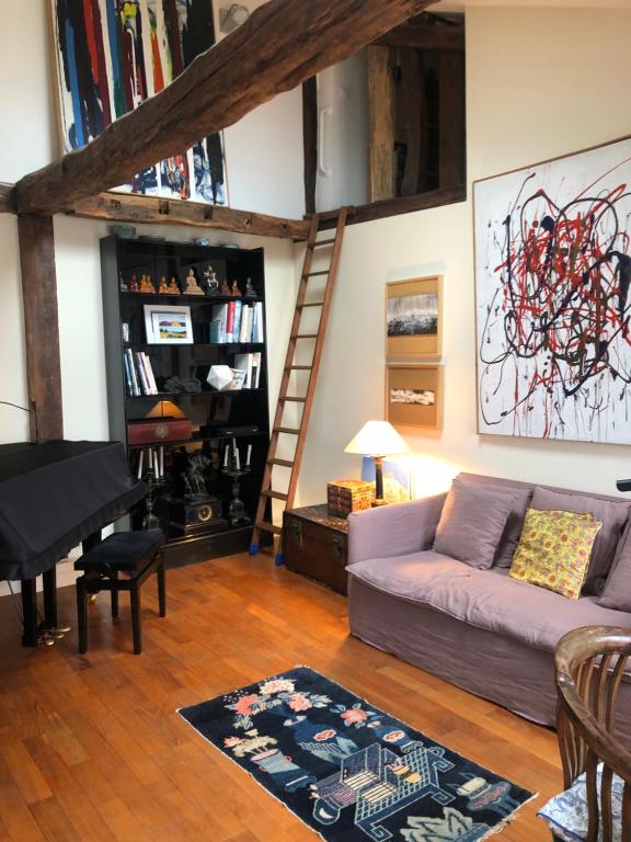 - un salon avec un canapé et un piano dans l'établissement Charming apartment on top floor in Marais -5P, à Paris