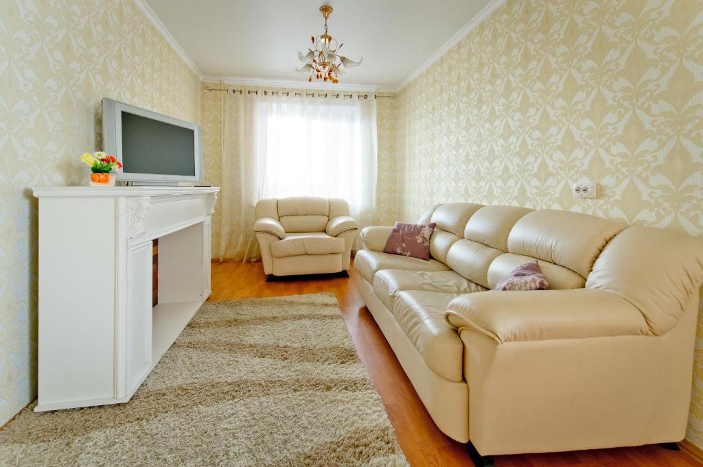 a living room with a couch and a television at Five Stars Comfort in Chelyabinsk