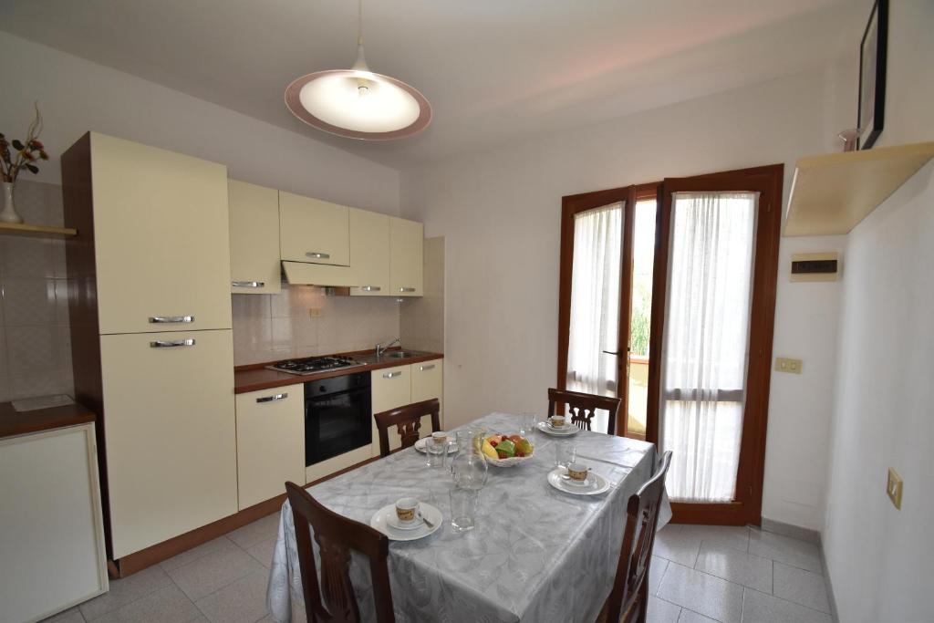 uma cozinha com uma mesa com cadeiras e uma toalha de mesa em Appartamento Amapola - Bilocale in zona mare con clima e posto auto em Marina di Campo