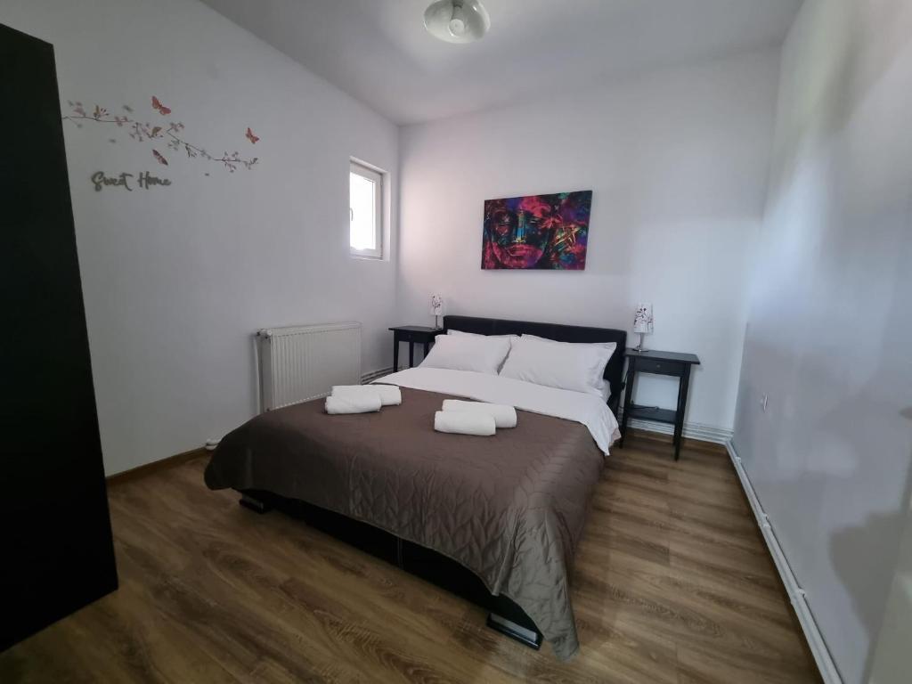 a bedroom with a bed with two towels on it at Parnica Home in Dudeştii Noi