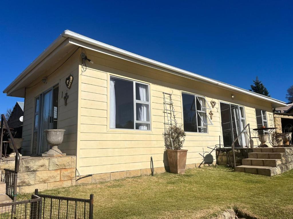 a small white house with a window and a yard at Twogether self catering in Clarens