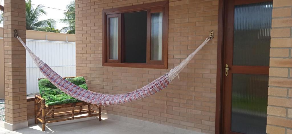 a hammock on the side of a house at Studios da ilha praia do Francês in Praia do Frances