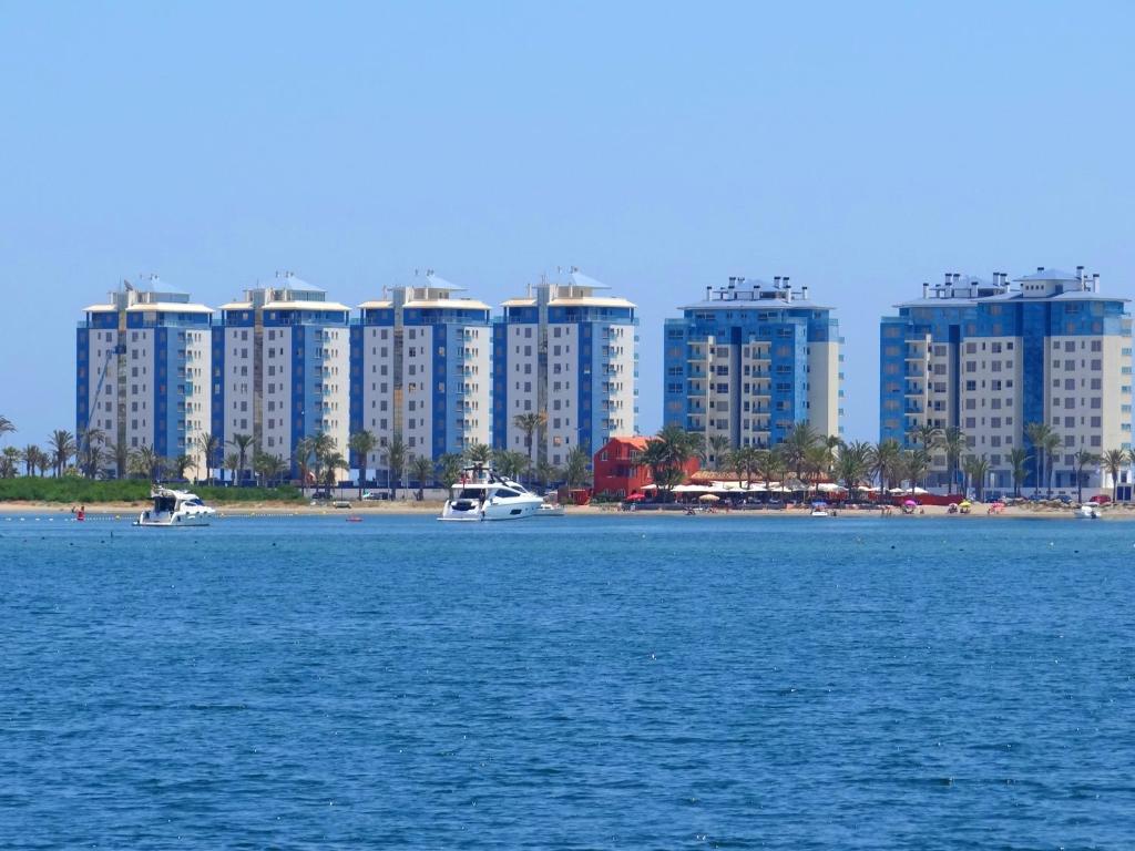 uma grande massa de água com edifícios ao fundo em Gran Lugar -Mar Azul em La Manga del Mar Menor