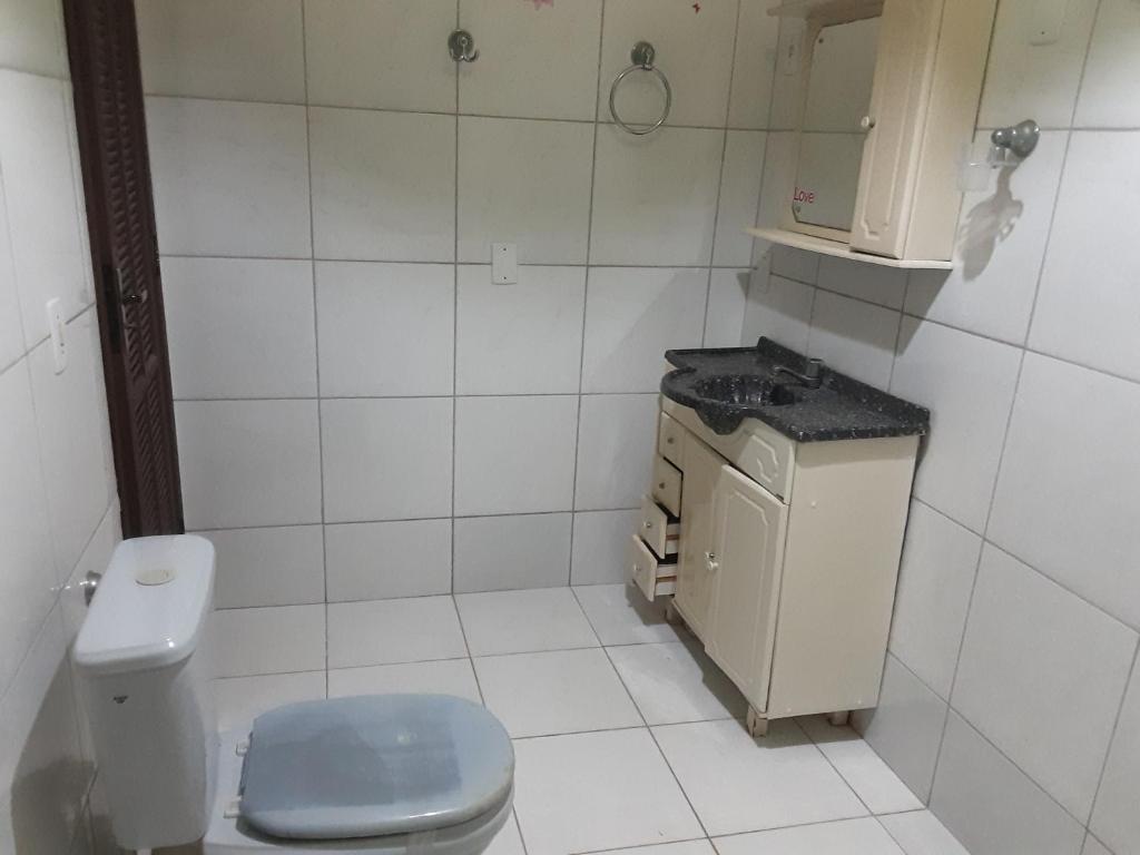 een witte badkamer met een toilet en een wastafel bij VERDEPERTO Camping Clube in Guarapari