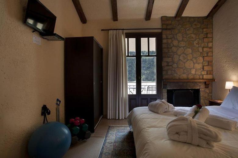 a bedroom with two beds and a fireplace at Fanaras Hotel in Kalavrita