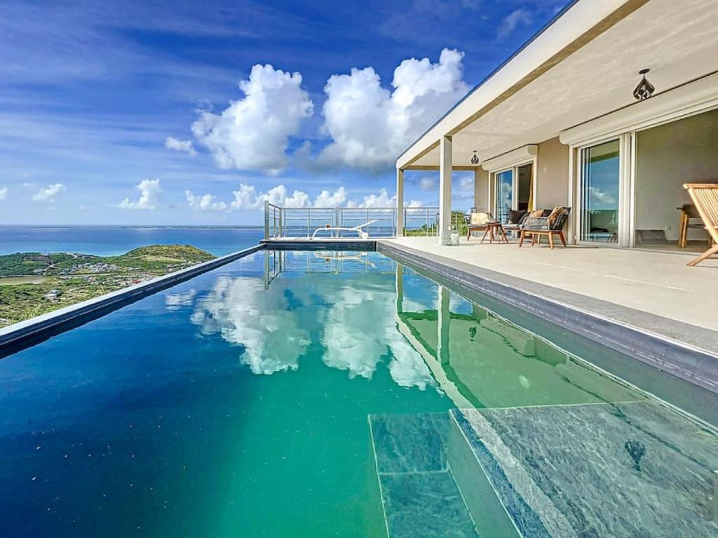 a swimming pool with a view of the ocean at Villa Grand Horizon with extraordinary 180 degree sea view in Saint Martin