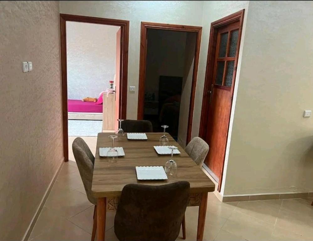 een eetkamer met een houten tafel en stoelen bij Super appartement in Aïn ej Jmel