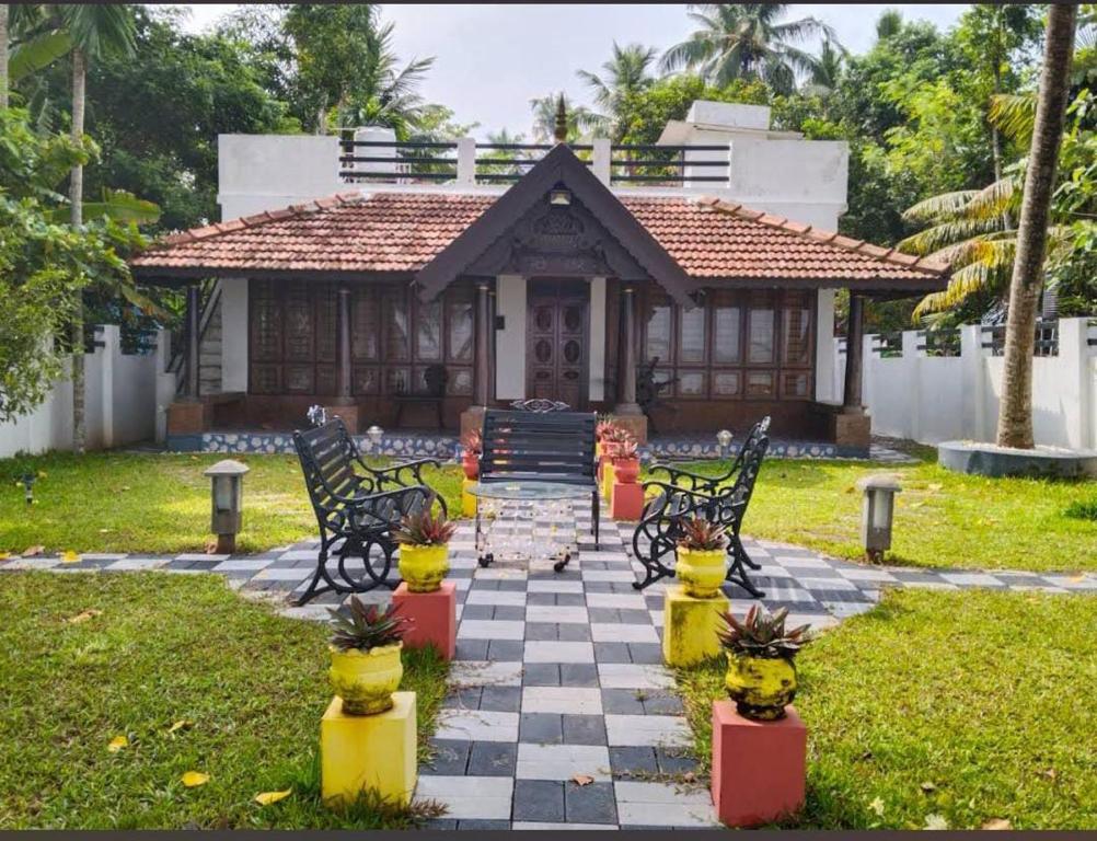 una casa con un tablero de ajedrez delante de una casa en Sambranikodi Resort and Home Stay, en Kollam