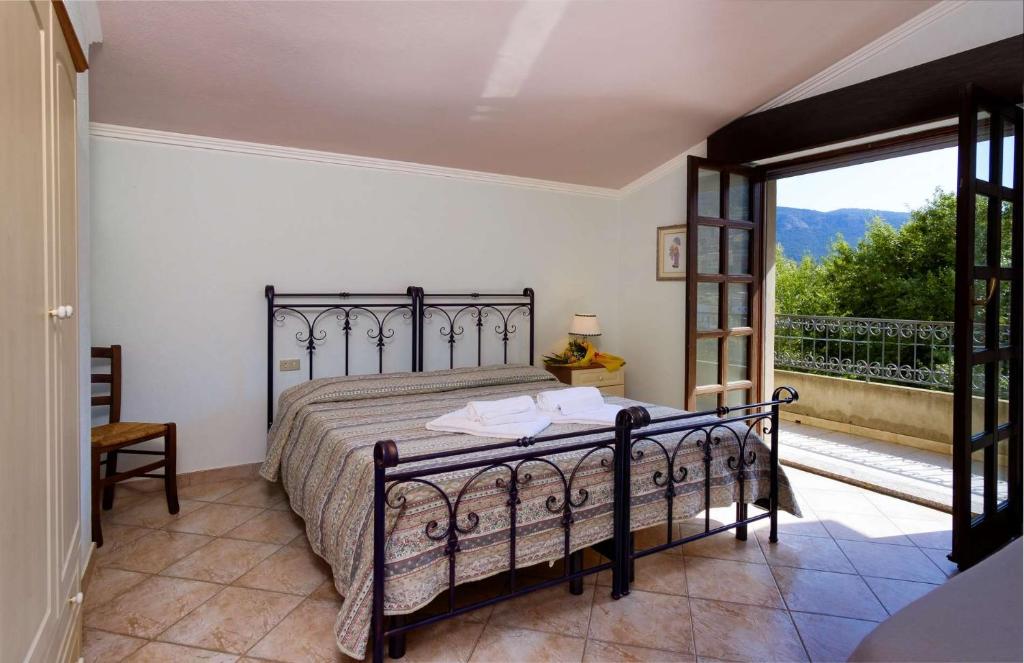 een slaapkamer met een bed en een groot raam bij BB Sa Mangaliana in Villagrande Strisaili