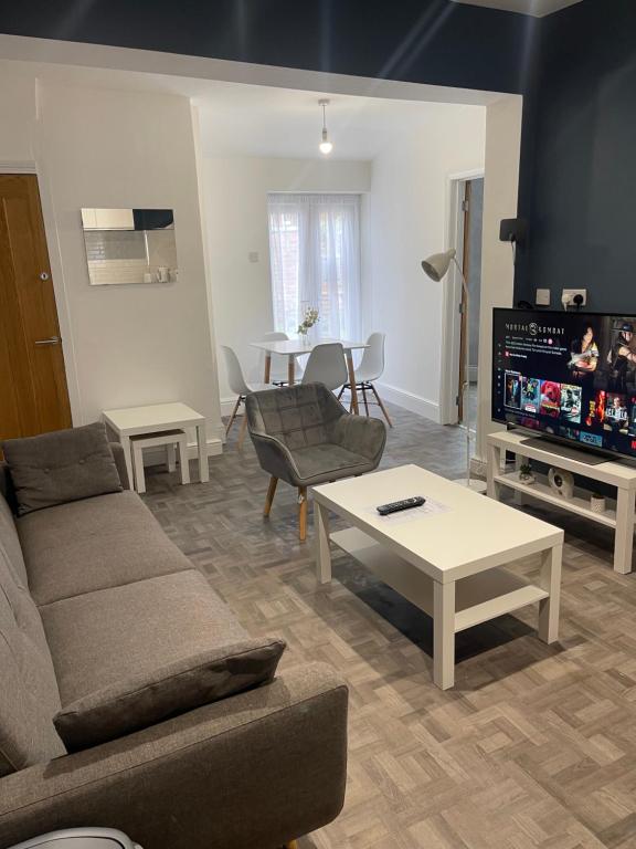 uma sala de estar com um sofá e uma mesa em Elegant 3 Bedroom Apartment em Rowley Regis