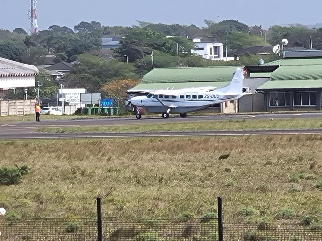 un petit avion est assis sur une piste dans l'établissement Airport Airbnb, à Richards Bay