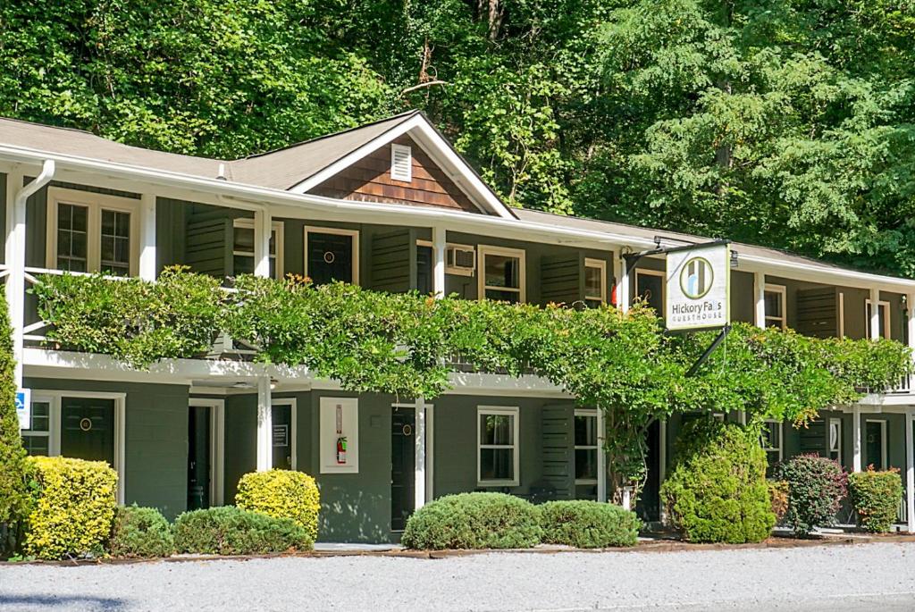 a green house with a sign in front of it at Hickory Falls Inn in Chimney Rock