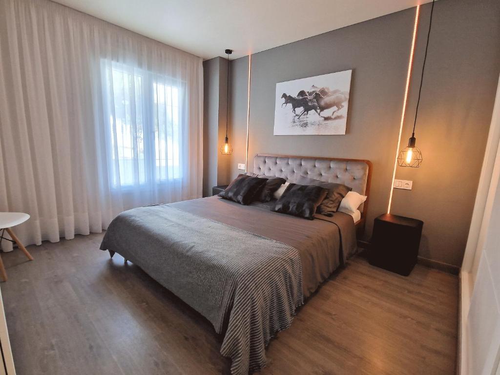 een slaapkamer met een groot bed en een raam bij Emerald Apartment - Spacious Modern 2 Bedroom in Benalmádena